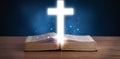 Open holy bible with glowing cross in the middle Royalty Free Stock Photo