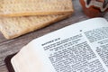 Open Holy Bible on the new testament Passover chapter with unleavened bread and a cup of wine on a wooden table Royalty Free Stock Photo