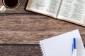 Open holy bible, notebook, and cup of coffee on wooden table, top view Royalty Free Stock Photo