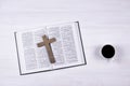 An open Holy Bible on the table. Wooden cross. Crucifix. A cup of coffee on the table. Royalty Free Stock Photo