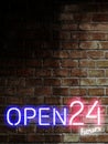 Open 24 hours in 7 days sign on rusty brick wall with copy space in vertical. Bar open light Neon Sign. Night store blue, red and