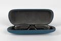 An open isolated glasses case containing a black pair of glasses set against a white background Royalty Free Stock Photo