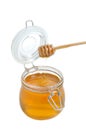 Open jar of honey and drizzler on white