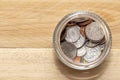 An open jar with small coins of American cents stands on a wooden table, close-up, selective focus. A concept for business and fin Royalty Free Stock Photo