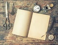 Open journal book and vintage writing tools on wooden table