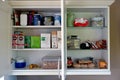 Open kitchen wall cabinet in domestic kitchen showing contents