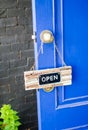 Open label hanging on blue door in garden Royalty Free Stock Photo