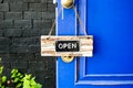 Open label hanging on blue door in garden Royalty Free Stock Photo