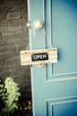 Open label hanging on blue door in garden Royalty Free Stock Photo