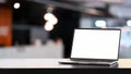 Laptop computer with blank screen on white table and conference room blurred background. Royalty Free Stock Photo