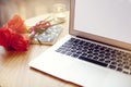 Open laptop computer with blank space for layout on a wooden table in cafe bar, St. Valentines flowers, note book during coffee br Royalty Free Stock Photo