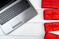 Open laptop computer and red gift boxes on white wooden desk in office, copy space. Flat lay, top view. Online shopping,  holiday Royalty Free Stock Photo