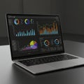 Open laptop on a dark table displaying data visualizations. Screen features colorful Royalty Free Stock Photo