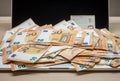 Open laptop and pile of money euro banknotes Royalty Free Stock Photo