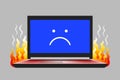 Open laptop with unhappy face icon on screen and flame Royalty Free Stock Photo