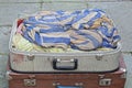 open large gray suitcase full of colored dirty clothes Royalty Free Stock Photo