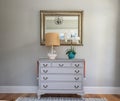 An open large and wide interior front door hallway foyer with a hanging light fixture, coastal colors and entry way