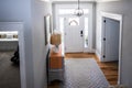 An open large and wide interior front door hallway foyer with transom, hanging light fixture, coastal colors and entry