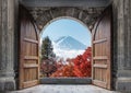 Open large wooden door with mount Fuji-san and autumn maple tree in blue sky