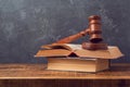 Open law book with judges gavel on wooden table. Courtroom or law enforcement office