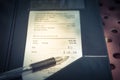 Open leather bill holder with restaurant check and pen