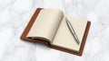 Open leather bound journal with a silver pen on a marble surface Royalty Free Stock Photo