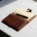 Open leather-bound notebook on a white surface, illuminated by natural light Royalty Free Stock Photo