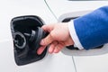 Open the lid of the fuel tank in the car. Vehicle refueling at a gas station businessman in a suit Royalty Free Stock Photo