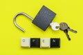 An open lock with keys on a yellow background the word open concept is laid out at the bottom of a computer keyboard Royalty Free Stock Photo