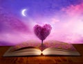 Open magic book of life, knowledge, wisdom. Fantasy, nature or learning concept with heart shaped tree Royalty Free Stock Photo