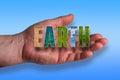 Open male hand, word Earth