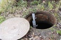 an open manhole of the city sewer and a ladder lowered into it Royalty Free Stock Photo