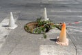 Open manhole marked with old traffic cones on a city street. Manhole with broken cover on a narrow road. Dangerous traffic