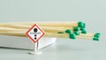 An open matchbox next to a Danger warning sign. Concept of teaching children and adults the rules of fire safety. Light green Royalty Free Stock Photo