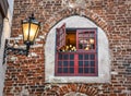 Open medieval wooden decorative window in an old brick home