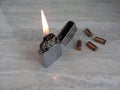 Open metal lighter with flame on black background. Royalty Free Stock Photo