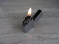 Open metal lighter with flame on black background Royalty Free Stock Photo