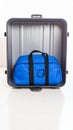 Open metallic suitcase with a blue duffel bag inside isolated on white background Royalty Free Stock Photo
