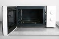 Open modern microwave oven on table Royalty Free Stock Photo