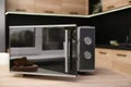 Open modern microwave oven on table