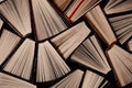 Open multi-colored old books stand on a bookshelf in the home library