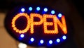 Open neon sign glowing in the dark. Vivid retro styled text at entrance on glass window. Colorful electric banner selective focus Royalty Free Stock Photo