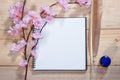 Open note book with pink sakura flowers on wooden background Royalty Free Stock Photo