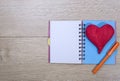 Open notebook with ballpoint pen and red heart of woo Royalty Free Stock Photo