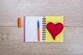 Open notebook with ballpoint pen and red heart of wool Royalty Free Stock Photo