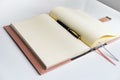 An open notebook with yellow sheets lies on a white table, next to a pen. Royalty Free Stock Photo