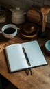Open notebook with blank pages amidst wooden kitchen items