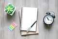 Open notebook with blank pages, and clock on wooden desk table Royalty Free Stock Photo