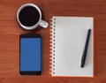 Open notebook with blank pages, mobile phone and coffee cup. Royalty Free Stock Photo