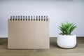 An open notebook with blank pages next to a green plant in a pot on a wooden table. Copy space. Retro style Royalty Free Stock Photo